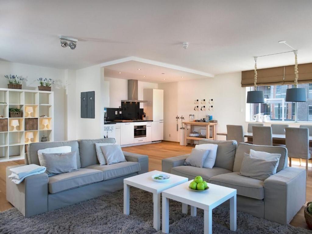 een woonkamer met 2 banken en een tafel bij Modern apartment in the harbor of Schevening in Scheveningen