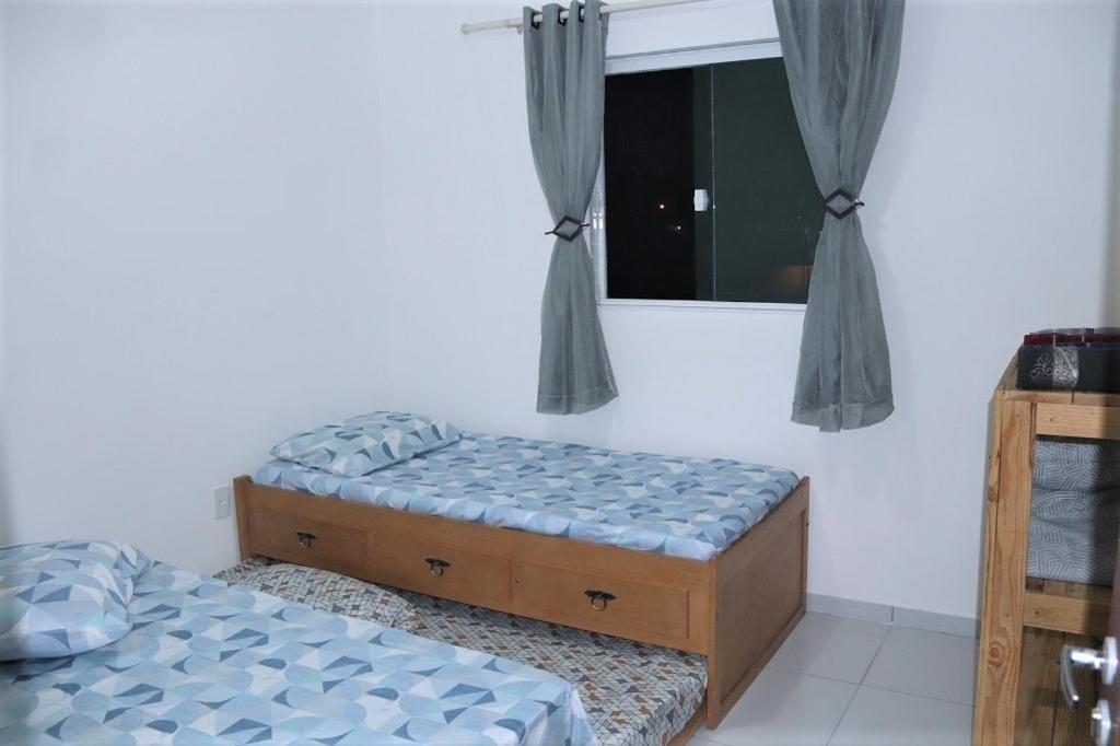 1 dormitorio con 2 camas individuales y ventana en Flat JOÃO PESSOA JACUMÃ, en Jacumã