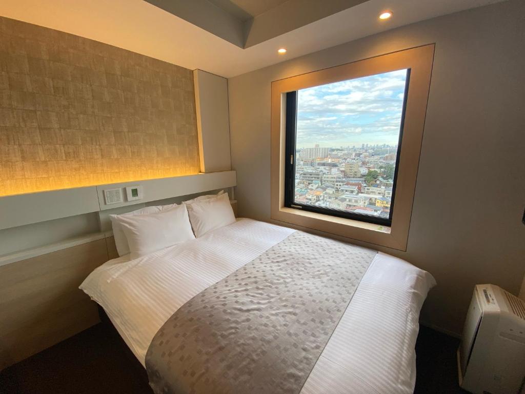 Postel nebo postele na pokoji v ubytování APA Hotel Keikyukamata Ekimae