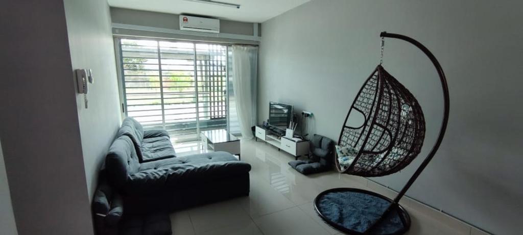 uma sala de estar com um sofá e um baloiço em TAR HOMESTAY em Lahad Datu