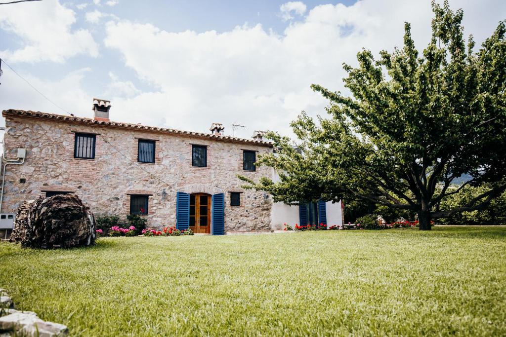 une ancienne maison en pierre avec une grande cour dans l'établissement Mas Fullat cottage, Alforja tarragona, à Alforja