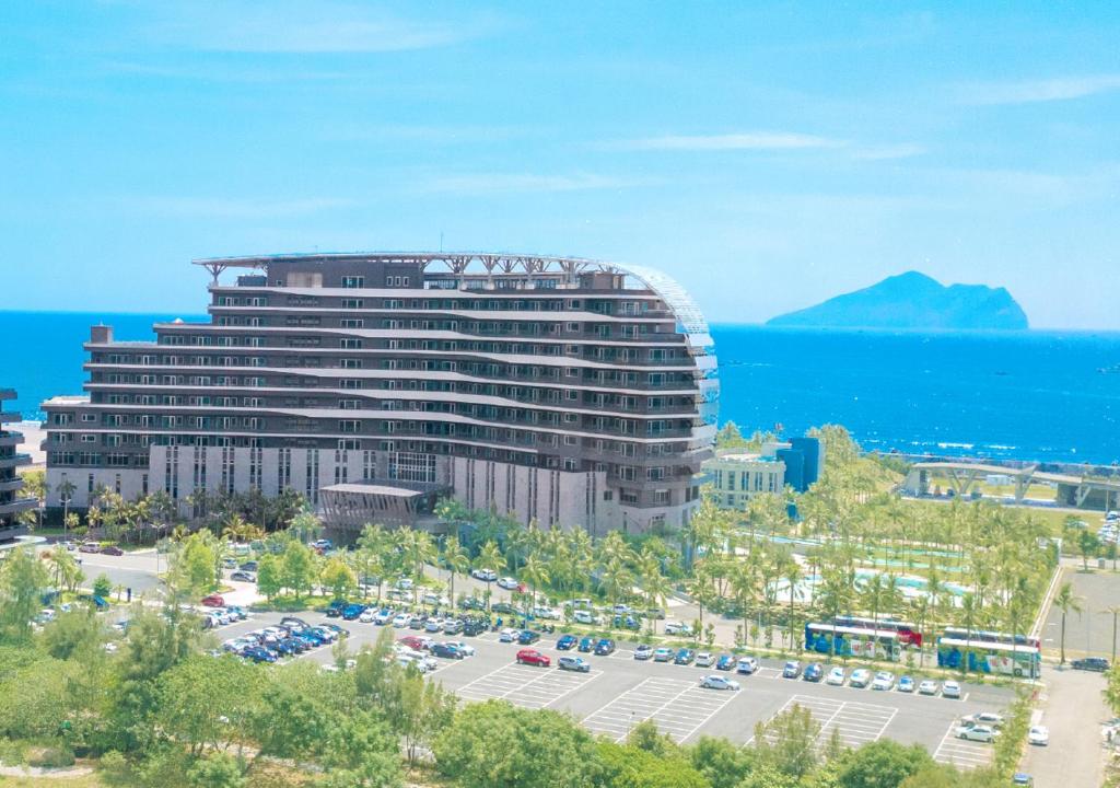 a large building with a parking lot in front of the ocean at The Archipelago in Toucheng