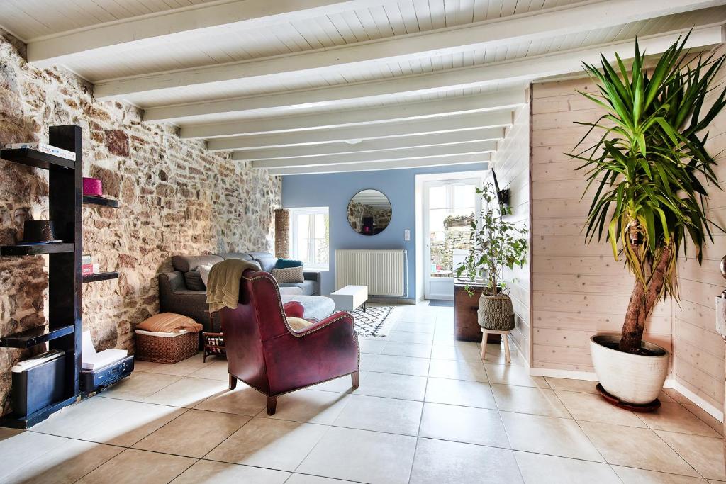 uma sala de estar com um sofá e uma cadeira em Maison Saint-Thomas em Cuiseaux