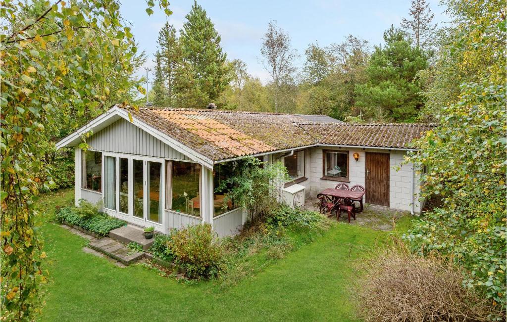 een klein wit huisje met een tuin ervoor bij Awesome Home In Vggerlse With Kitchen in Bøtø By
