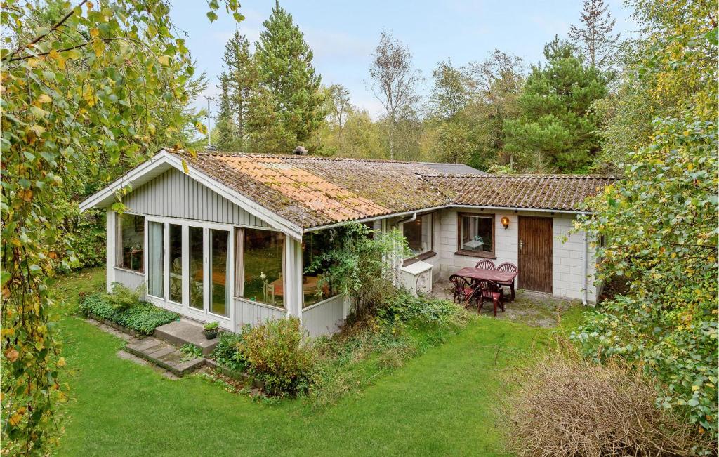 a small white cottage with a garden in front of it at Holiday Home Skovlindvej Iii in Marielyst