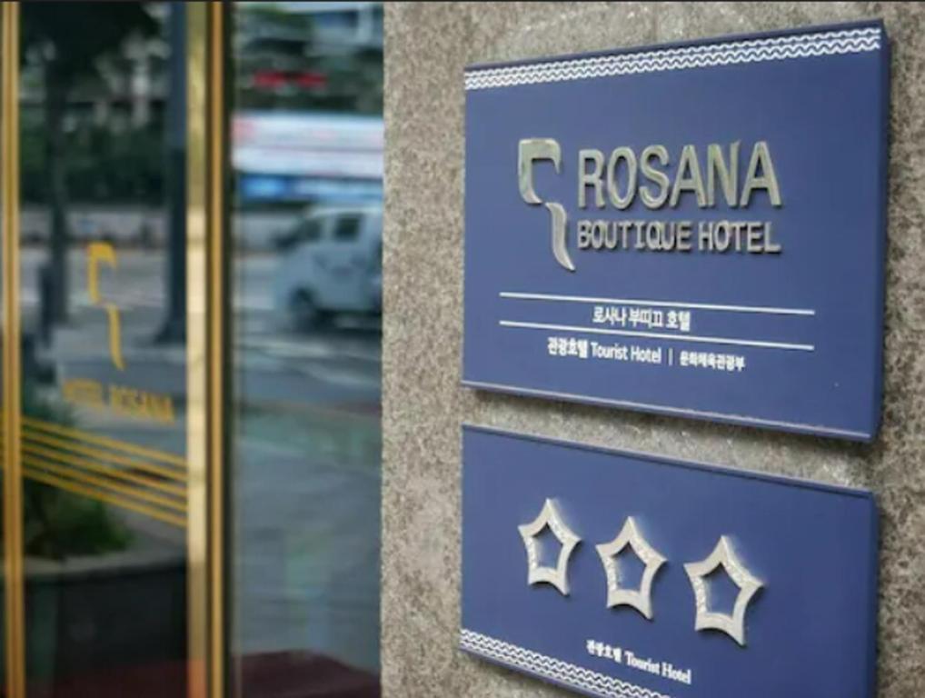 twee borden aan de zijkant van een gebouw bij Rosana Hotel in Seoul