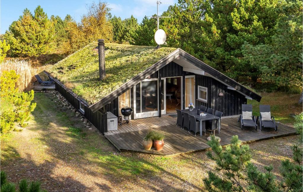 una casa negra con techo de hierba y mesa en Stunning Home In Rm With Sauna, en Bolilmark