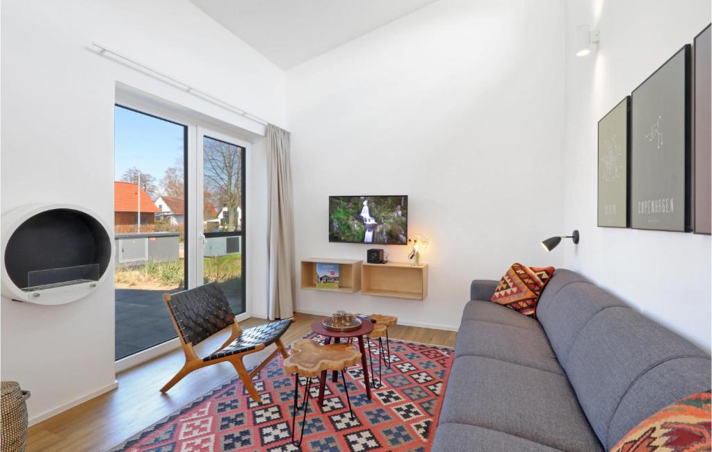 uma sala de estar com um sofá cinzento e uma televisão em 2 Bedroom Beach Front Home In Lembruch-dmmer See em Lembruch