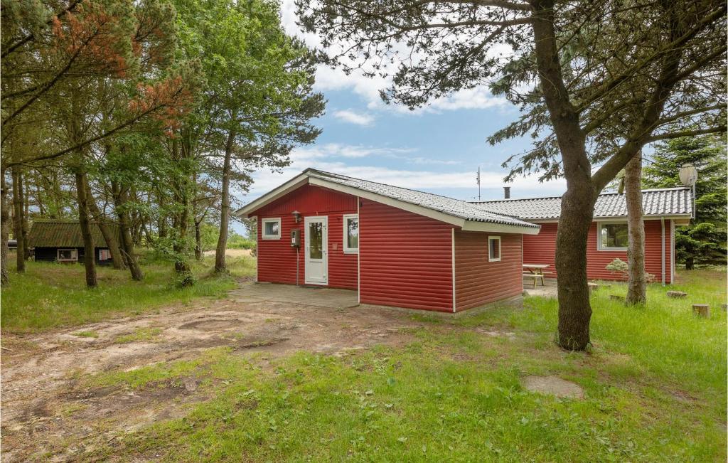 a red cabin in the middle of a forest at Nice Home In Rm With House Sea View in Rømø Kirkeby