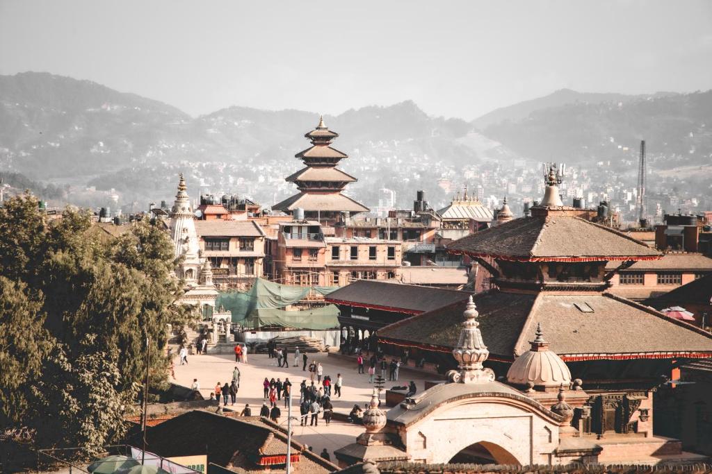 a group of buildings with people walking in a city at Laxmi Homestay with main square view in Bhaktapur