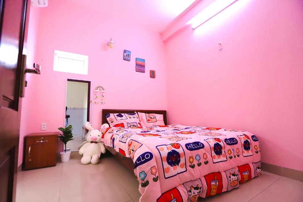 Phương Trang Hotel Vũng Tàu في فنغ تاو: غرفة نوم وردية مع سرير وحيوانات محشوة