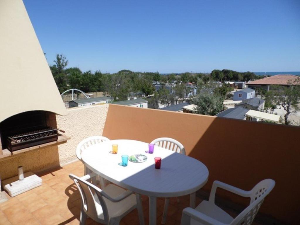 une table et des chaises sur un balcon avec vue dans l'établissement Appartement studio cabine mezzanine, 4-6 couchages, parking privé, proche plage - FR-1-326-592, à Marseillan