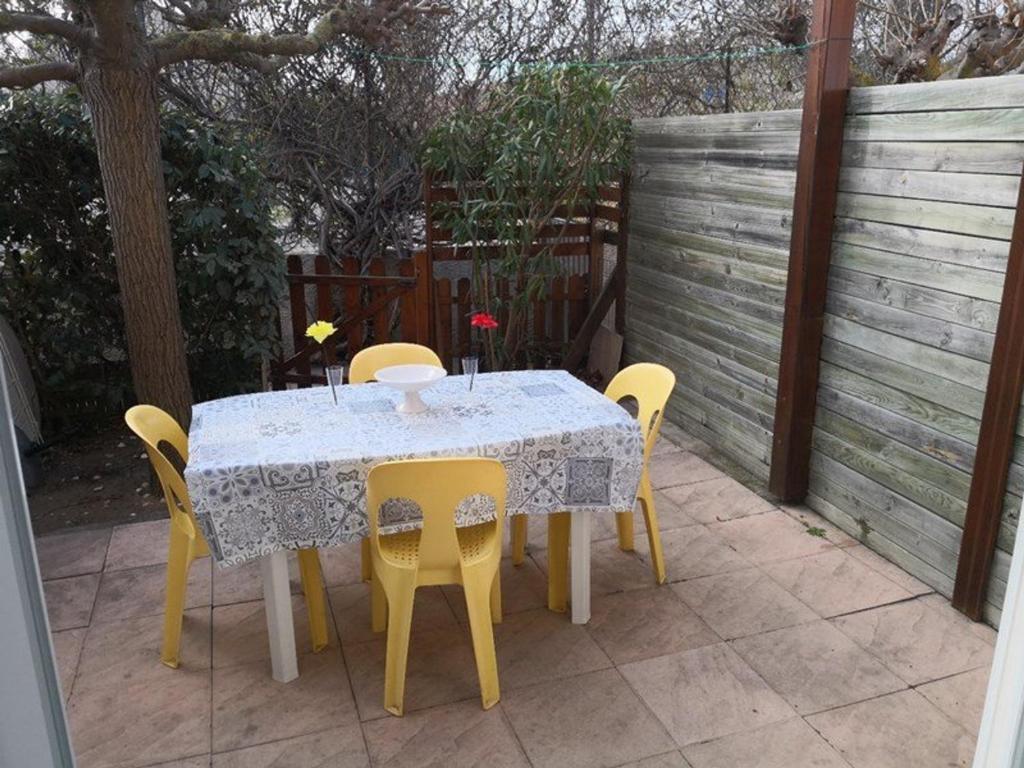 une table et des chaises assises sur une terrasse dans l'établissement Maison avec Piscine Proche Plage, 5 Couchages et Parking Privé - FR-1-326-685, à Marseillan