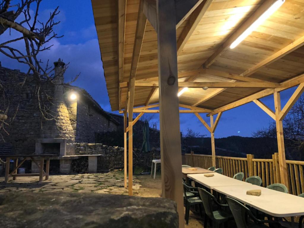 pérgola de madera con mesas y sillas en el patio en Solano de Moran en Murillo de Gállego