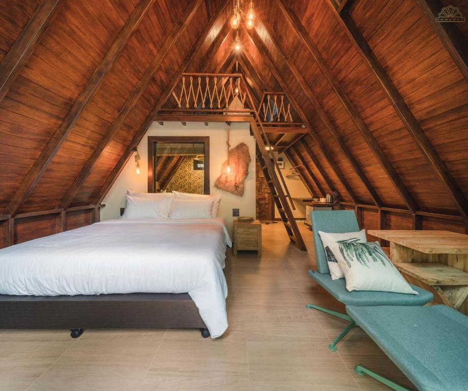 ein Schlafzimmer mit einem Bett und einem Stuhl im Dachgeschoss in der Unterkunft Kenaray Farmstay riverside in Kaeng Kachan