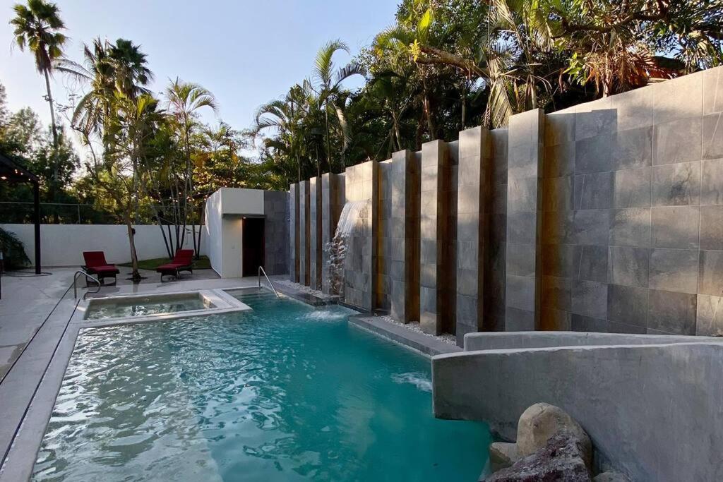 a swimming pool with a waterfall and a retaining wall at Beautiful Residence in Marina, Vallarta in Puerto Vallarta