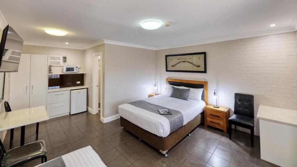 a hotel room with a bed and a kitchen at Country Leisure Motor Inn in Dubbo