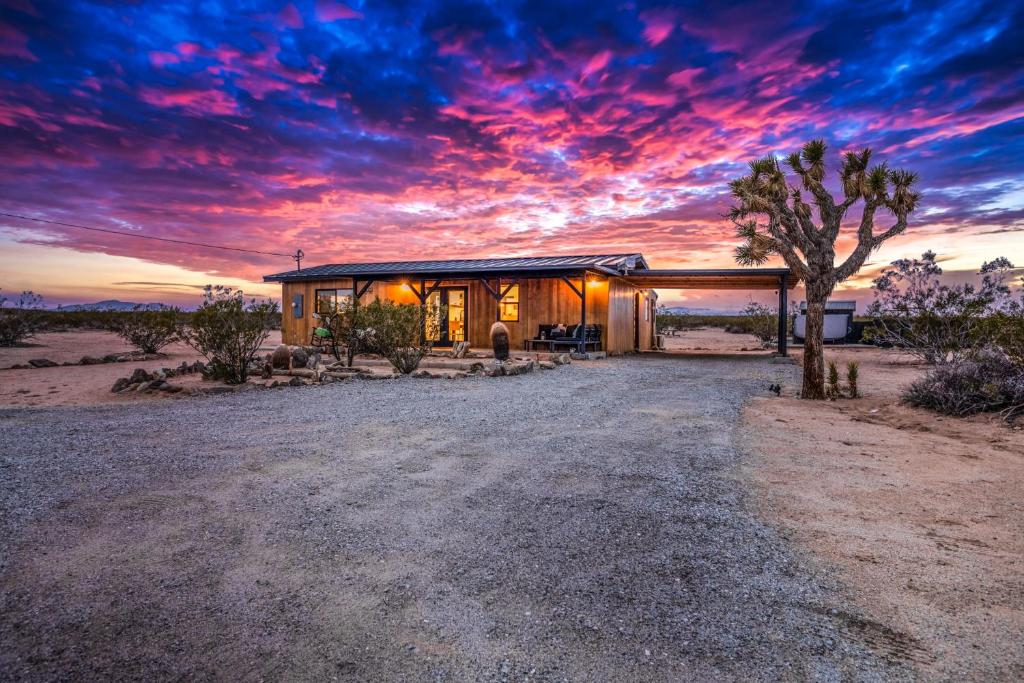 a house in the middle of the desert with a sunset at Views, Hot Tub, Fire Pit, 3 Acres in Sunfair Heights