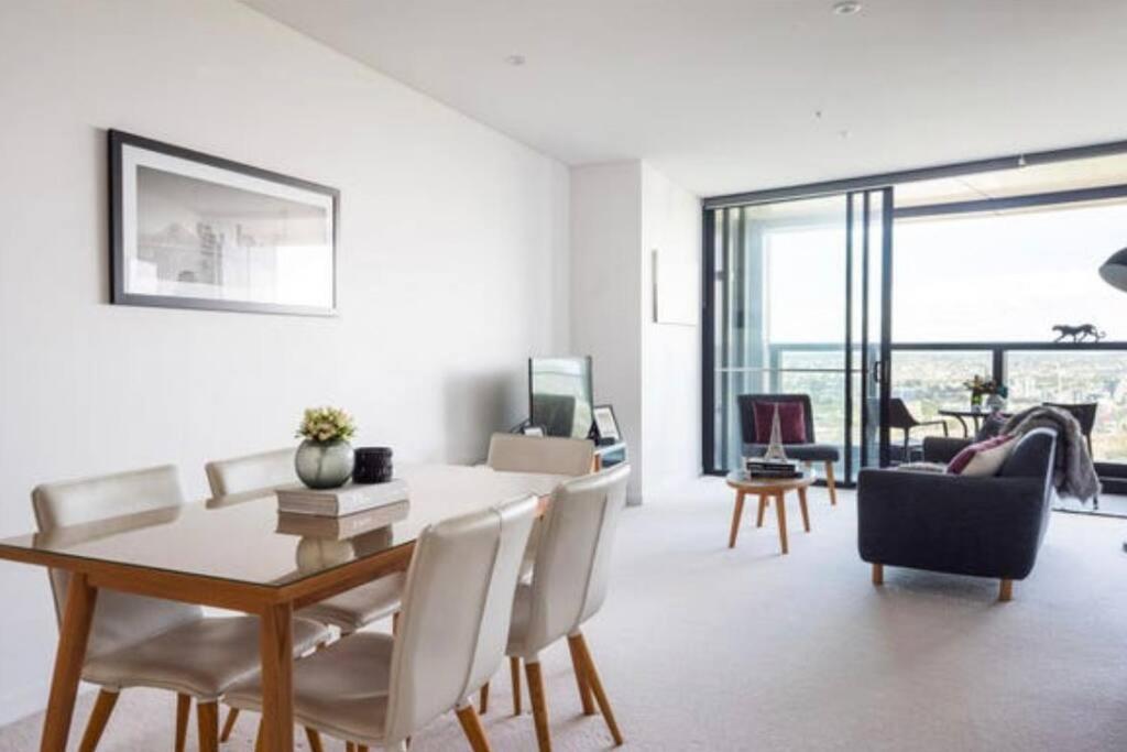 een woonkamer met een eettafel en stoelen bij L19 Spacious Apt, Wi-Fi, Parking by Stylish Stays in Brisbane