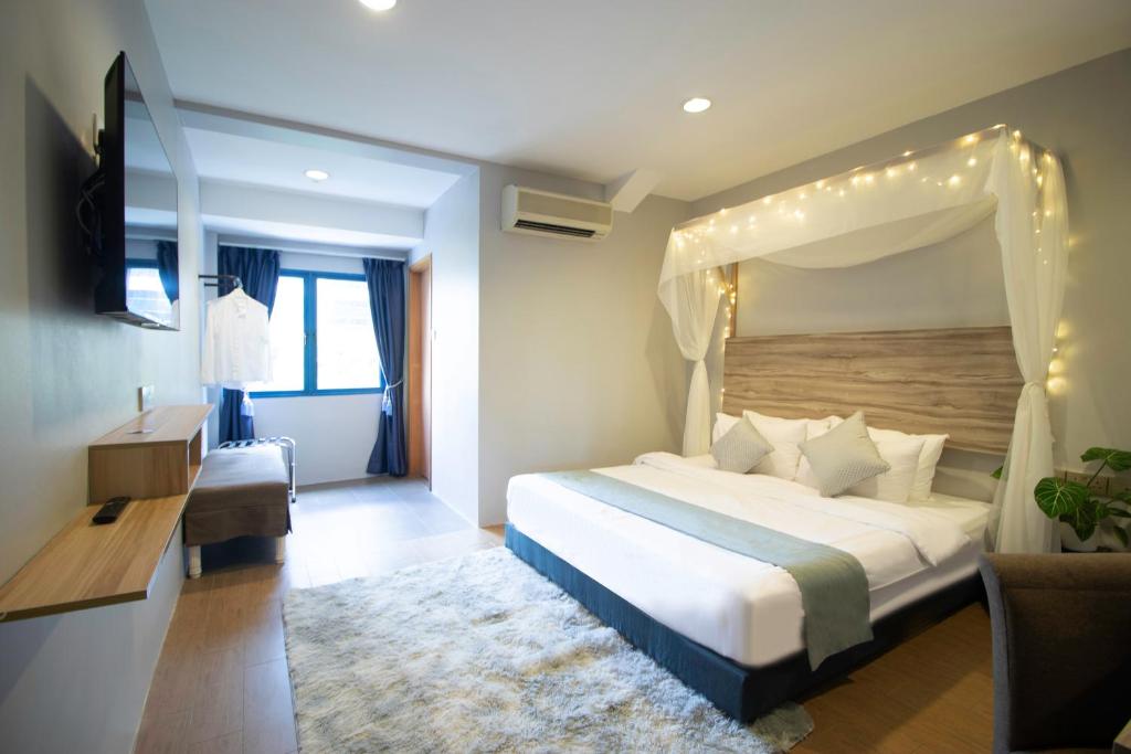 - une chambre avec un lit à baldaquin dans l'établissement Victoria Hotel a NuVe Group Collection, à Singapour