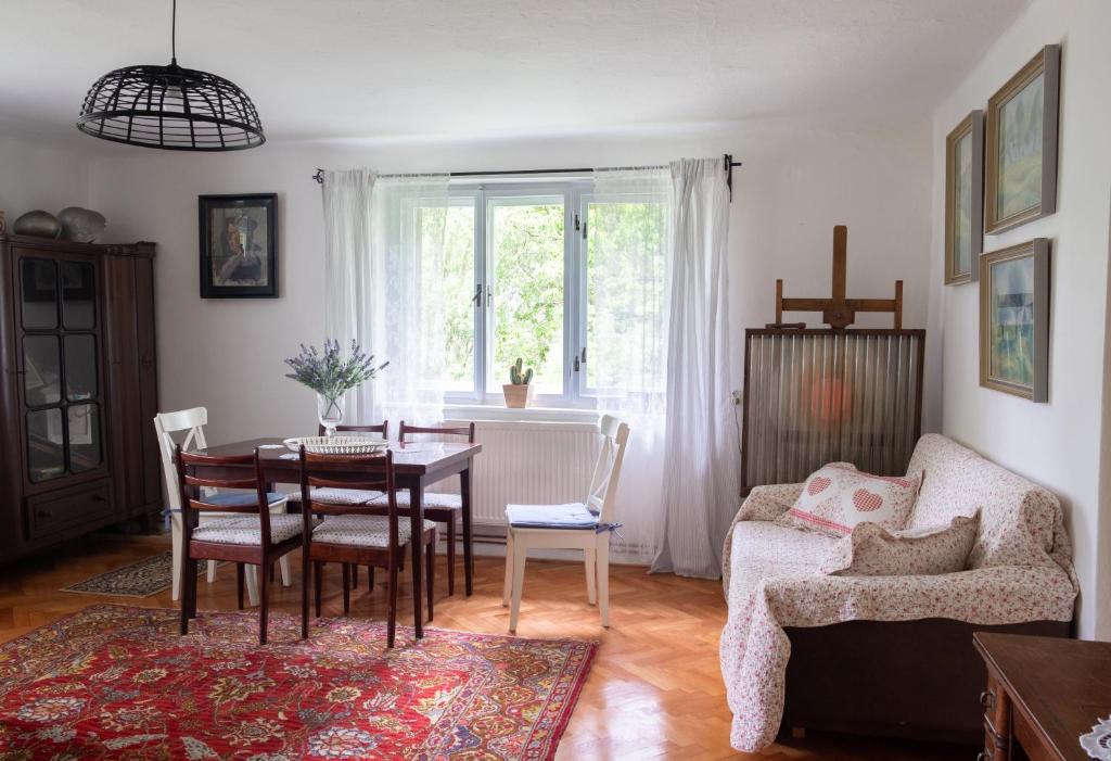 a living room with a table and chairs and a couch at Chaloupka pod skalou in Libošovice