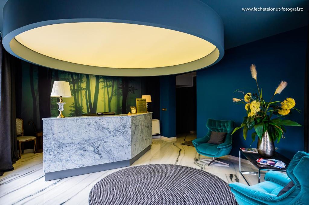 una hall con pareti blu e un grande soffitto di Hotel Brilliant Plaza a Zalău