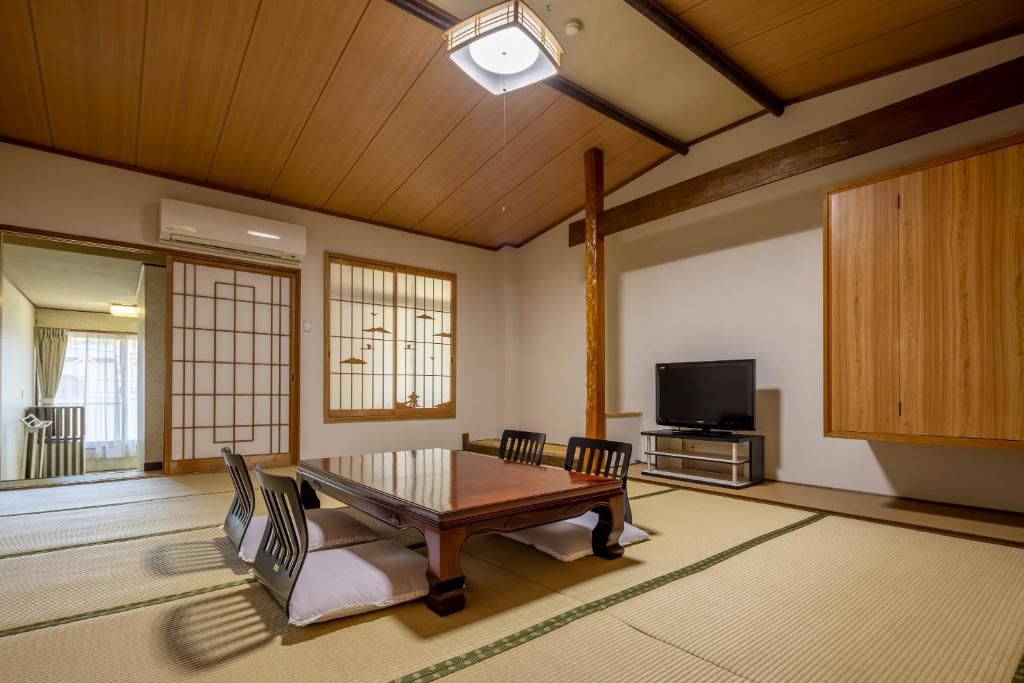 a living room with a table and a tv at Sawaki in Imabari