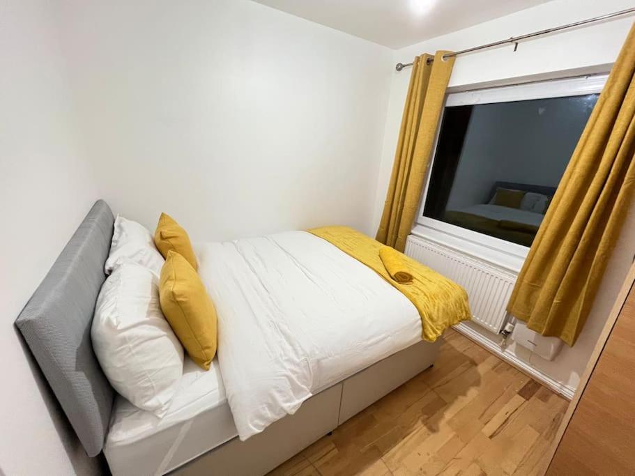 a bedroom with a bed with yellow pillows and a window at San Pedro- Anchorage in North Woolwich