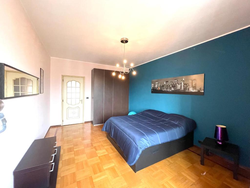 a bedroom with a bed and a blue wall at Feels like home in Turin