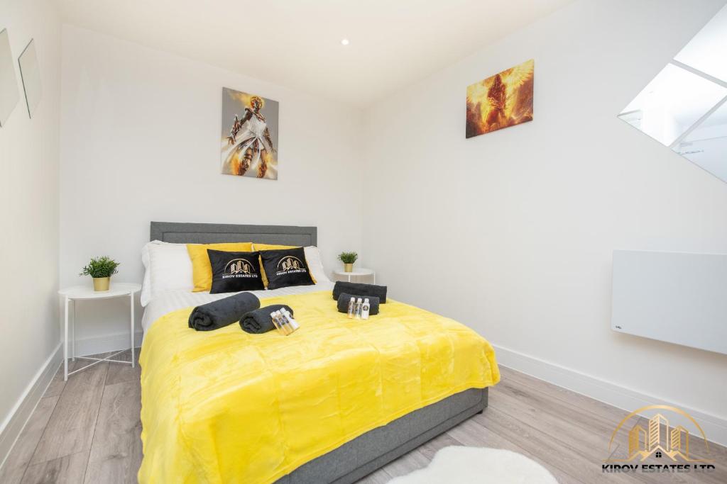 a bedroom with a bed with a yellow blanket at Hermes Apartment - The Messenger of Town in Southampton