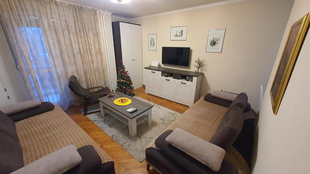 a living room with two couches and a christmas tree at Apartman Jogi in Vračar (historical)