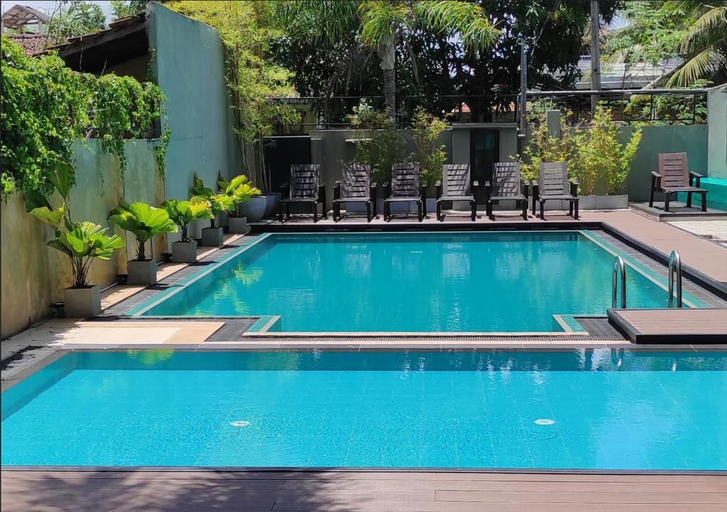 una gran piscina con sillas y una piscina en Morning Star Resorts en Negombo