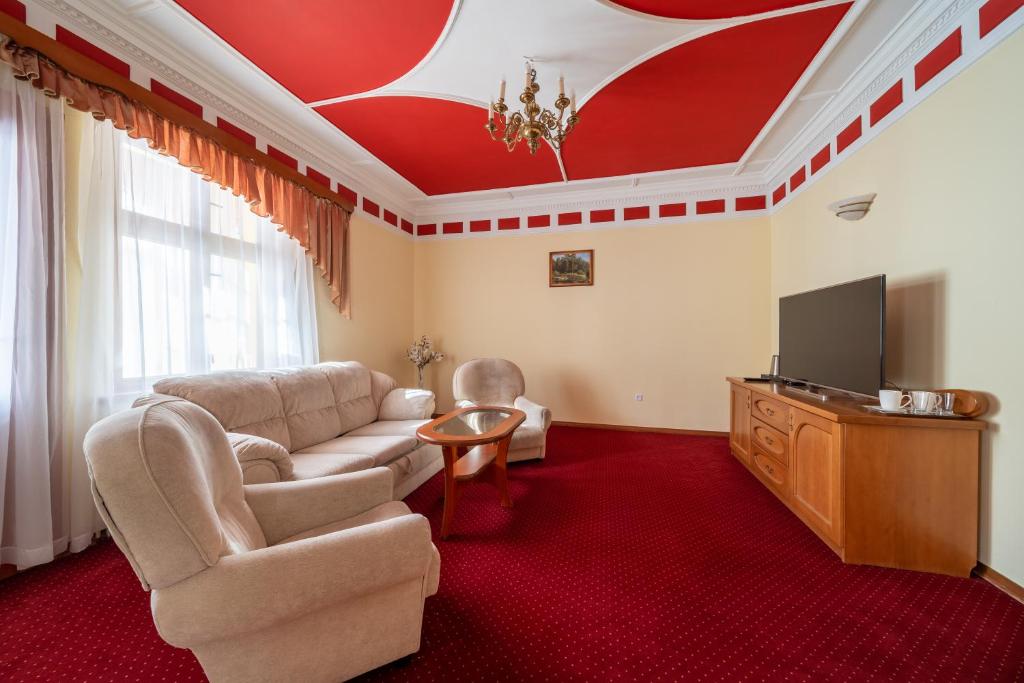Rezydencja PATRIA في كارباش: غرفة معيشة مع أريكة وتلفزيون بشاشة مسطحة