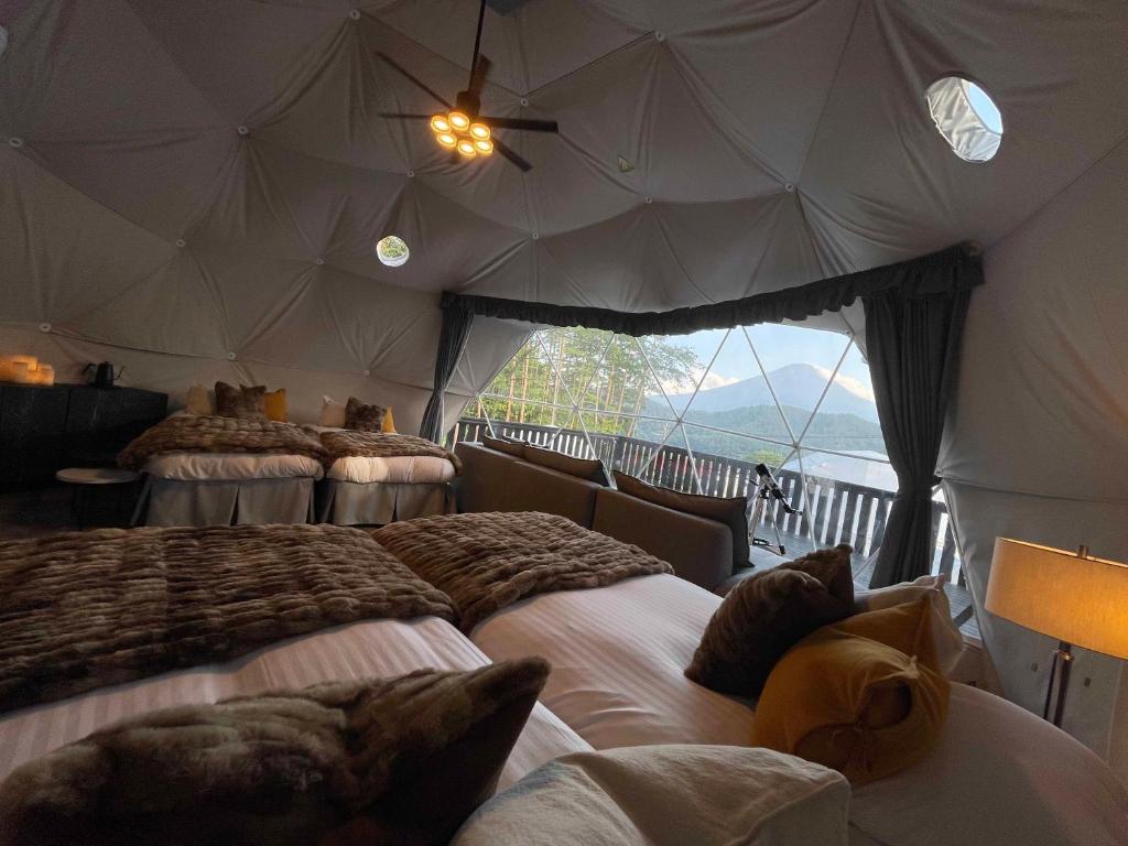 富士河口湖的住宿－TOCORO. Mt.Fuji CAMP&GLAMPING，帐篷内一间卧室,配有四张床