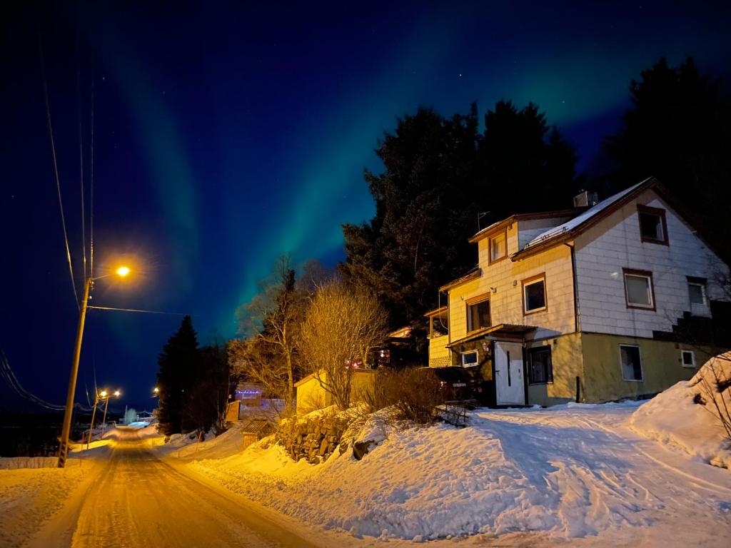 a house on a snow covered street at night at Senja, Skaland apartment in Skaland