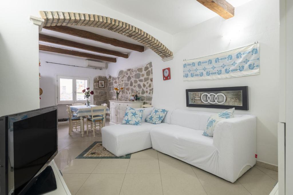 LoceriにあるCasa Vacanza Il Muralesのリビングルーム(白いソファ、テレビ付)