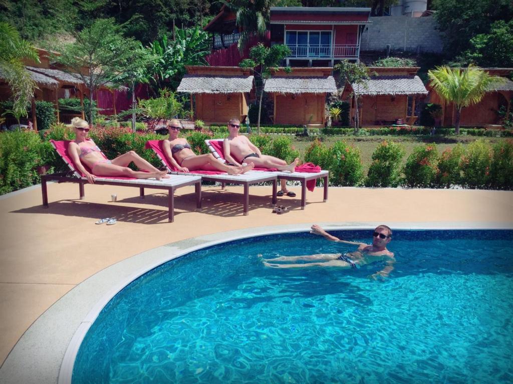 a group of people sitting in a swimming pool at Chom Dao Resort in Ko Lanta