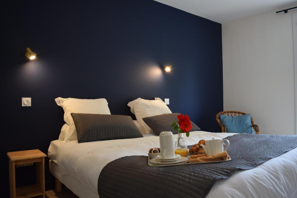 a bedroom with a bed with a tray of food on it at Hôtel et appartements les platanes in Thueyts
