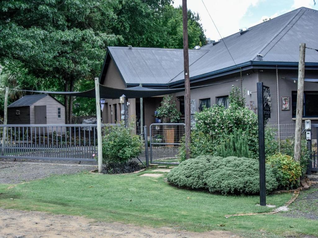 ein Haus mit einem Zaun vor einem Hof in der Unterkunft Stay!inClarens in Clarens