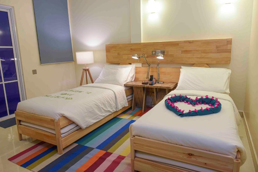 a bedroom with two twin beds and a desk at One The Island in Naifaru