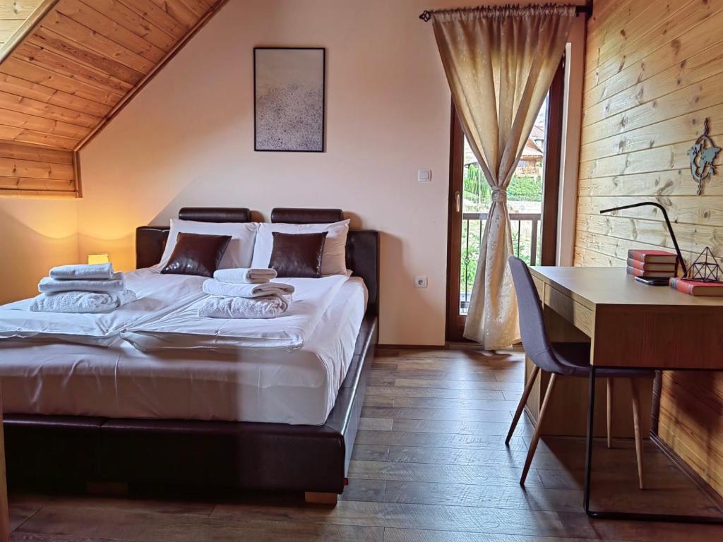 a bedroom with a large bed and a desk and a desk at Rustic dream MIA in Zlatibor