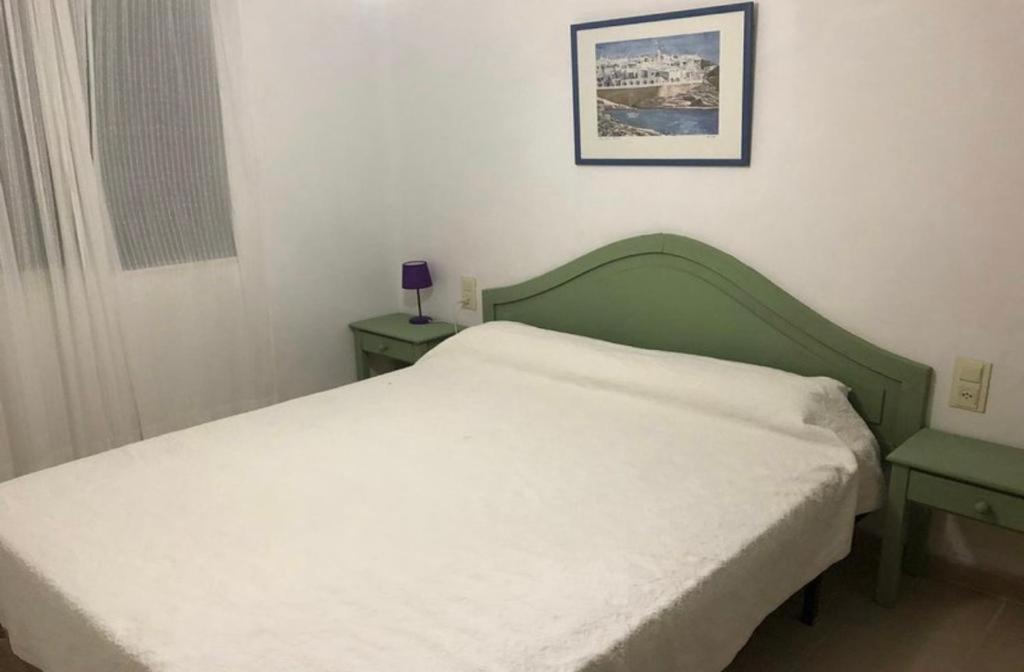1 cama en un dormitorio con 2 mesas y una foto en Son Parc Menorca recién reformado!, en Son Parc