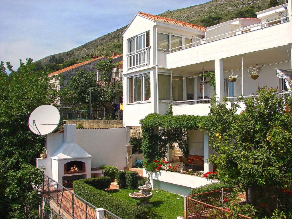 a large white house with a fireplace in a yard at Apartments Rock Palace in Dubrovnik