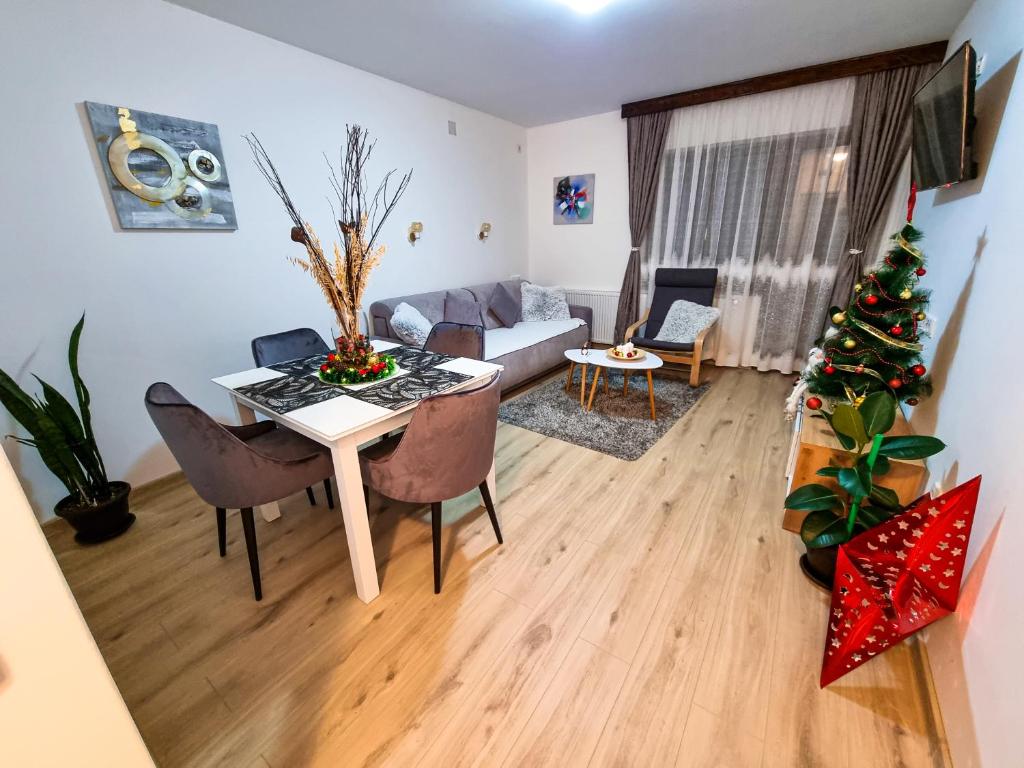 a living room with a table and a christmas tree at Apartmani "Vila Jelena" Arandjelovac in Arandjelovac