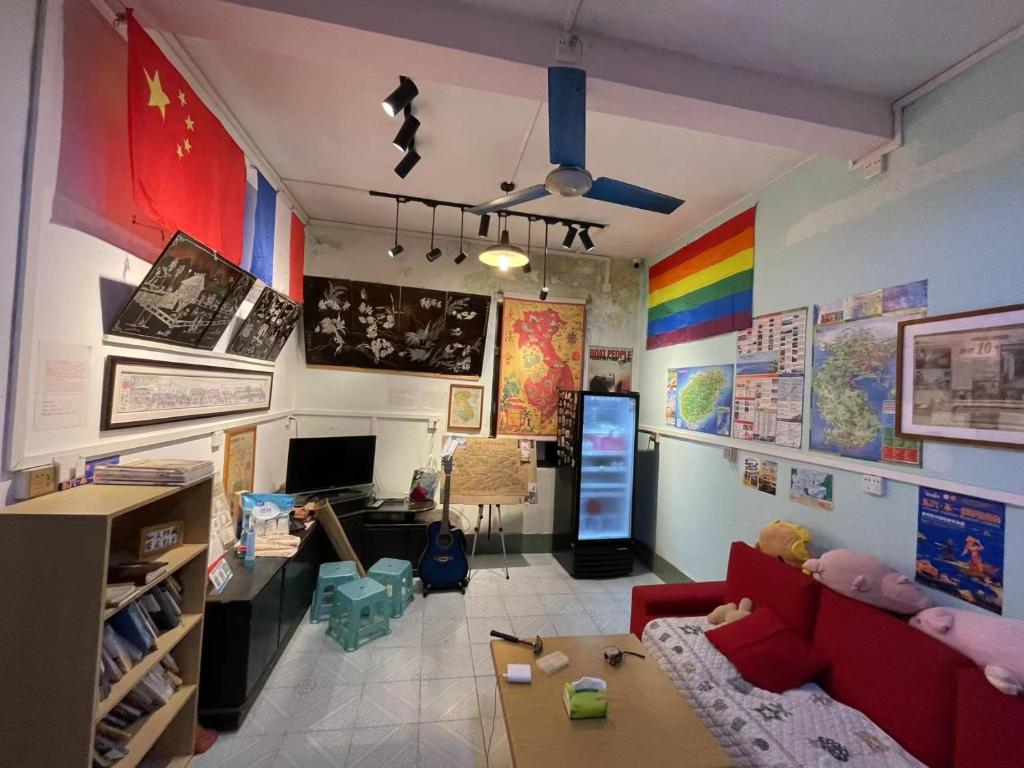 sala de estar con sofá y pared de arco iris en Kwangchowan Hostel, en Zhanjiang