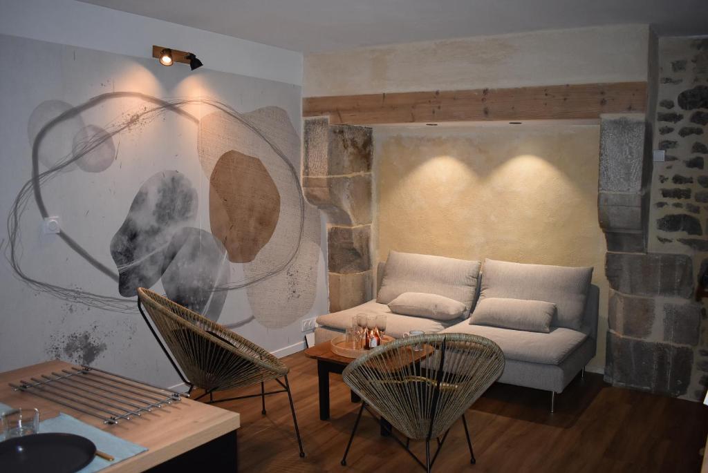 un soggiorno con divano e 2 sedie di Le Duclos, appartement rez-de-jardin Dinan centre a Dinan