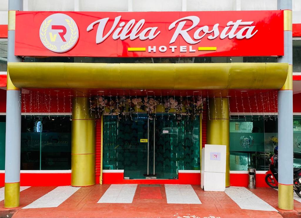 Villa Rosita Hotel في نجا: فندق عليه علامة حمراء وصفراء