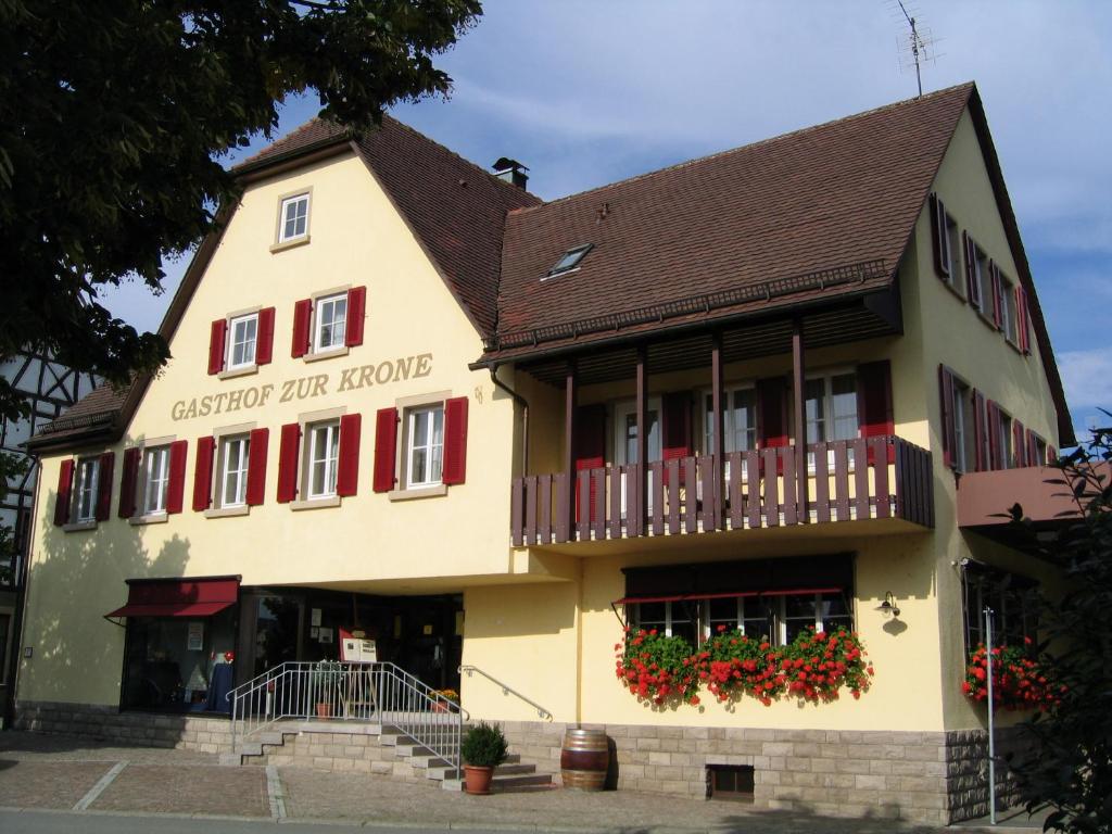 ein großes gelbes Gebäude mit roten Fensterläden in der Unterkunft Gästehaus in der Brückenstraße Jagsthausen in Jagsthausen