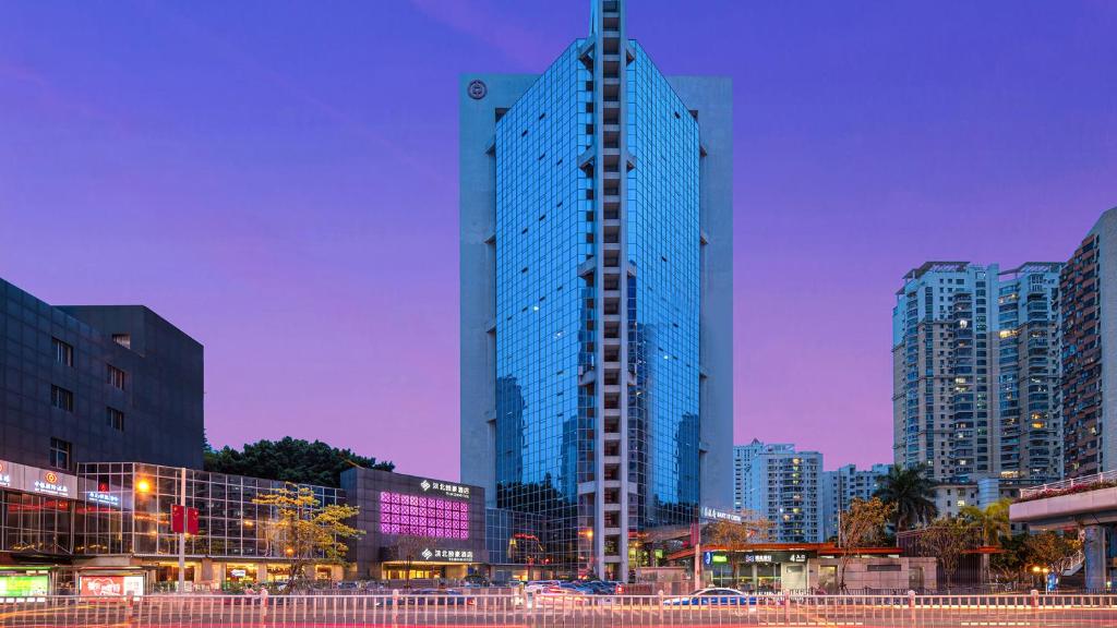 wysoki szklany budynek w mieście w nocy w obiekcie Binbei Yiho Hotel w mieście Xiamen