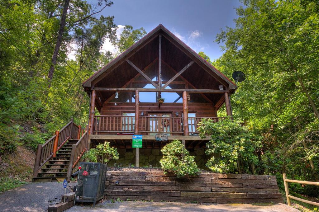 a cabin in the woods with stairs leading up to it at A Secluded Bearadise #247 in Sevierville
